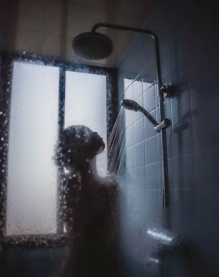 A Wet Wash Trick To Help Revive Dry, Frizzy, Damaged Hair - Woman in Shower - Image by Hannah Xu - Unsplash.com
